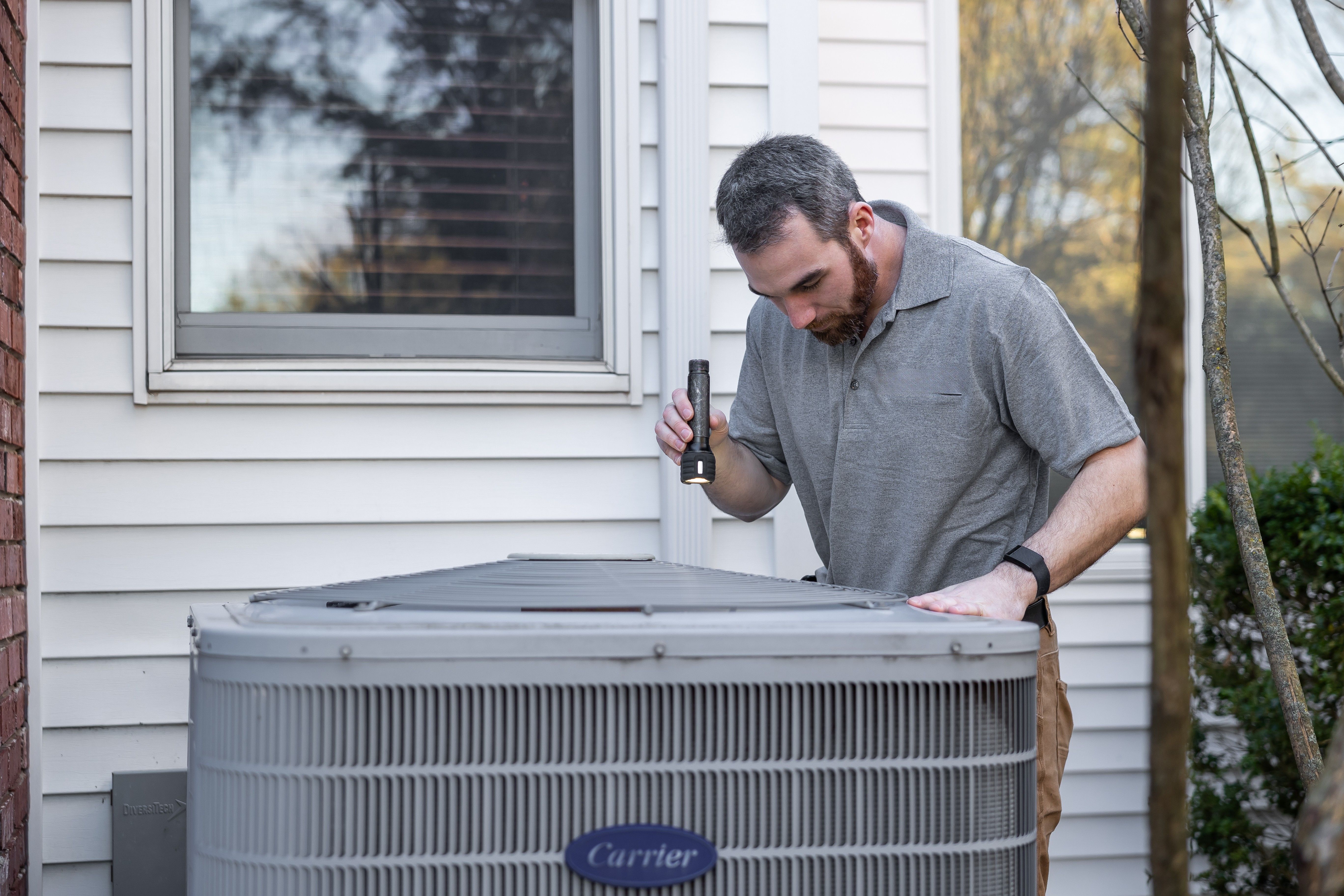 HVAC technician servicing an outdoor air conditioning unit